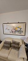 Full view of framed floral painting above sofa