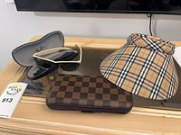 Sunglasses in case, wallet, visor hat displayed together