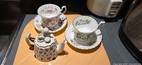 Overall lot showing two teacup sets and miniature teapot