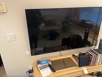 Wall-mounted Samsung 55" TV with cables visible