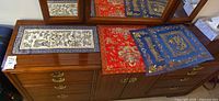 Three silk panels displayed on dresser