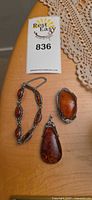 Bracelet, teardrop pendant, oval brooch displayed on table