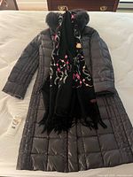 Front view of Fuchs Schmitt grey quilted down coat with black embroidered scarf draped over it