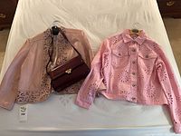 Overall shot of both jackets and purse on bed