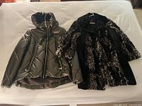 Both jackets laid flat on bed: Nuage puffer left, Adrienne Landau faux-fur right
