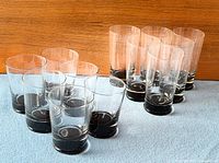 All twelve Orrefors tumblers arranged showing clear walls and smoky bases
