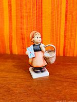 Front view of Hummel figurine on wood surface