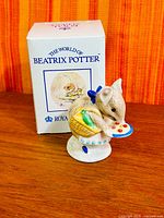 Front view of Applely Dapply figurine beside original box