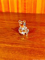Full view of Swarovski crystal teddy bear figurine on wood surface