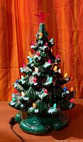 Full view of ceramic Christmas tree showing lights and base