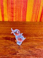 Side view of faceted Swarovski crystal duck figurine on wood surface