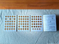 Entire open tri-fold coin folder showing three filled panels and information page