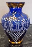 Front view of cobalt blue vase showing white enamel figures and gold accents