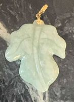 Front view of carved jade leaf pendant with gold bail