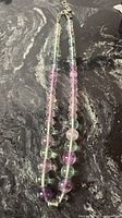 Full view of fluorite beaded necklace laid flat showing extender chain and clasp