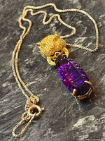 Full view of necklace with tiger head pendant and purple crystal drop