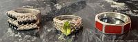 Front view of three sterling silver rings showing gemstone and enamel details