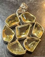 Front view of sterling silver pendant with seven pale yellow stones and filigree bail