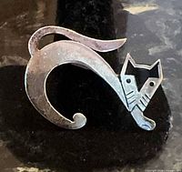 Front view of sterling silver cat brooch showing design and patina