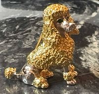 Front view of gold-tone poodle brooch showing textured coat, rhinestone eyes, silver-tone accents