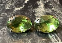 Front view of both earrings showing olive green faceted glass stones and prong settings