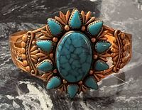 Front view of copper cuff showing central oval faux turquoise and surrounding teardrop stones