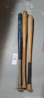 Three wooden baseball bats side by side, full length view