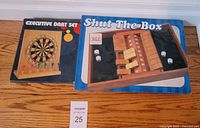 Both boxed games side by side on floor: Executive Dart Set at left, Shut The Box at right