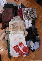 Pile of folded pants, shorts, pajama bottoms and socks on floor