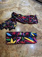 Clutch purse closed with matching scarf laid above, showing pattern and colors