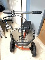 Front view of KneeRover scooter showing basket, wheels, handlebar