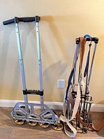 6-wheel stair-climber hand truck and two folded 2-wheel carts with straps against wall