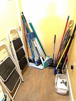 Group of cleaning tools and step stools leaning against walls