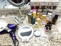 Overview showing perfumes, body mists, nail polishes, mirrors and hair tools on countertop