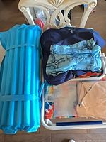 All five items on chair including roll-up blue float, fabric chair float, boxed float and others