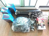 Lot overview showing three snowflake light boxes, bag of mini lights, twig sprays, boxed inflatable