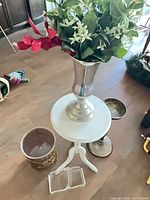 all five decorative items grouped: table, silver vase with faux flowers, gold planter, silver pedestal, acrylic towel holder