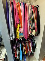 Wide view of upper clothes rail showing variety of tops and sweaters in multiple colours