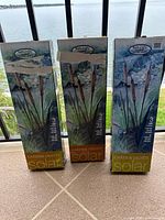 Front view of three Naturally Solar cattail garden light boxes