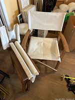 Two folded canvas pieces and one assembled chair showing wood frame and canvas upholstery