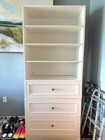 Front view of white laminate bookcase showing shelves and drawers