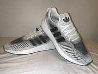 lateral view of both Adidas shoes showing knit pattern and stripes