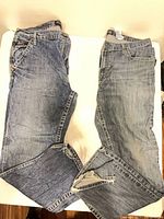 Both pairs of jeans laid flat showing overall condition