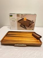 Tray removed from box showing wood surface, phone stand and hinge