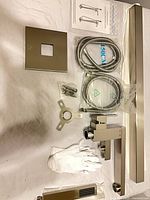 Complete kit laid out showing spout, hoses, trim plate, hardware, instructions