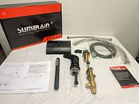 Complete faucet kit components with box and paperwork