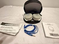 Headphones folded in case with cable and documents