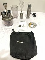 All components laid out including motor, attachments, beaker, pouch, manual, disc