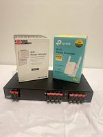Overall lot showing both boxed Wi-Fi range extenders and HomTech HTS4 selector