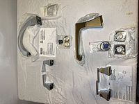 Both faucet sets laid out with spouts, handles, hardware and instructions visible